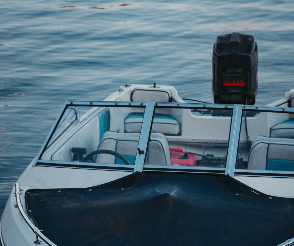 Außenborder eines kleinen Motorbootes, welches im Wasser liegt. 