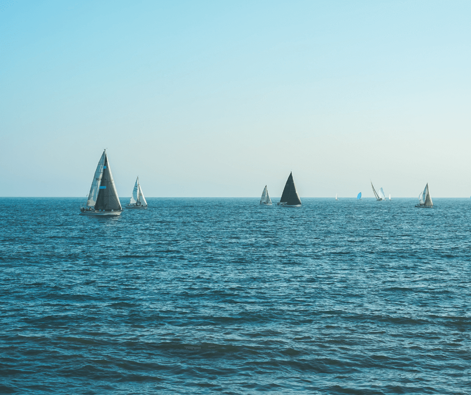 Segelboote mit offenen Segeln unterwegs auf dem blauen Wasser des Meeres mit einem leeren Horizont