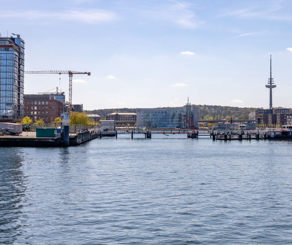 Aussicht auf die Kieler Förde mit Hafenanlage und Fernsehturm im Hintergrund.