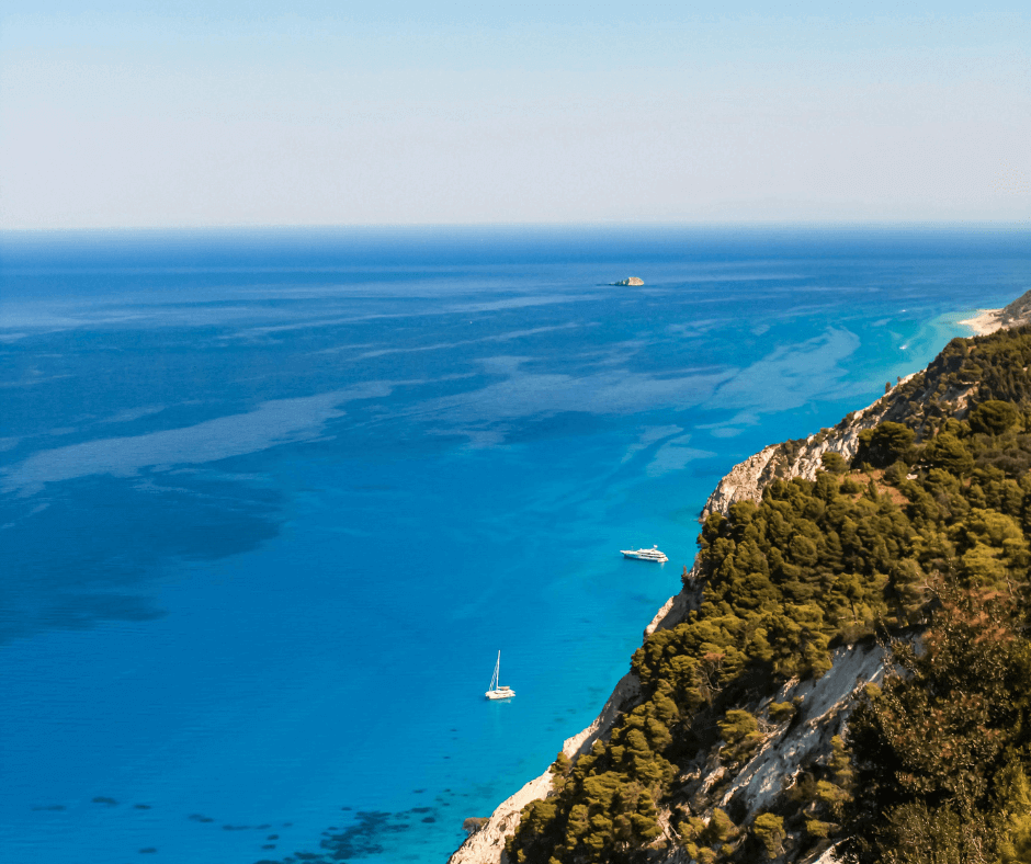 Segelboote auf dem Meer sind zu sehen. Herum sind die Klippen der Insel Lefkada.