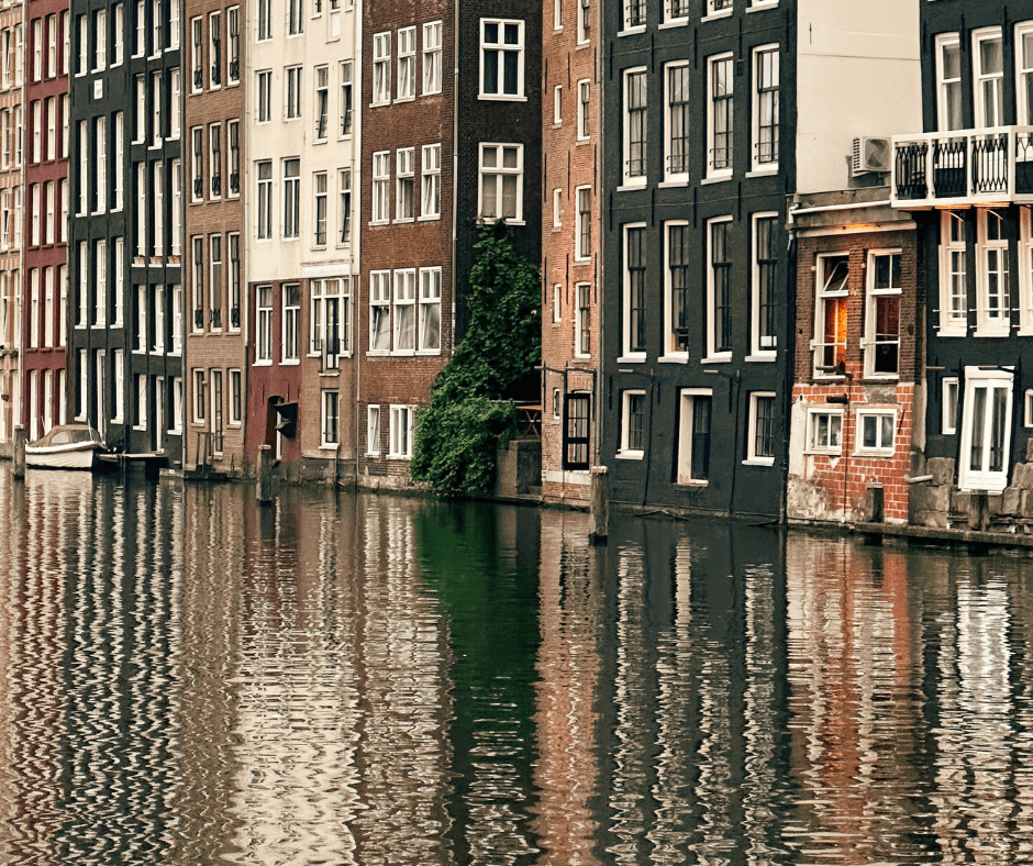Die Wasserstraßen Amsterdams und Gebäude im Hintergrund - verbringen Sie ein verlängertes Wochenende mit Familien und Freunden auf einem Hausboot in den Niederlanden.
