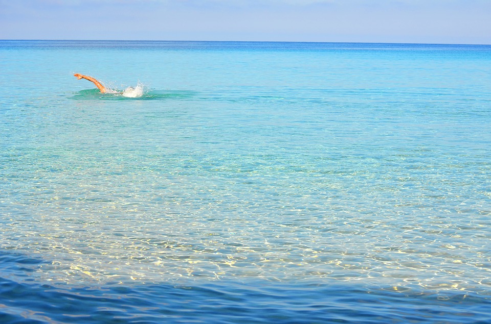 Persona nadando en las aguas azul turquesa del mediterráneo
