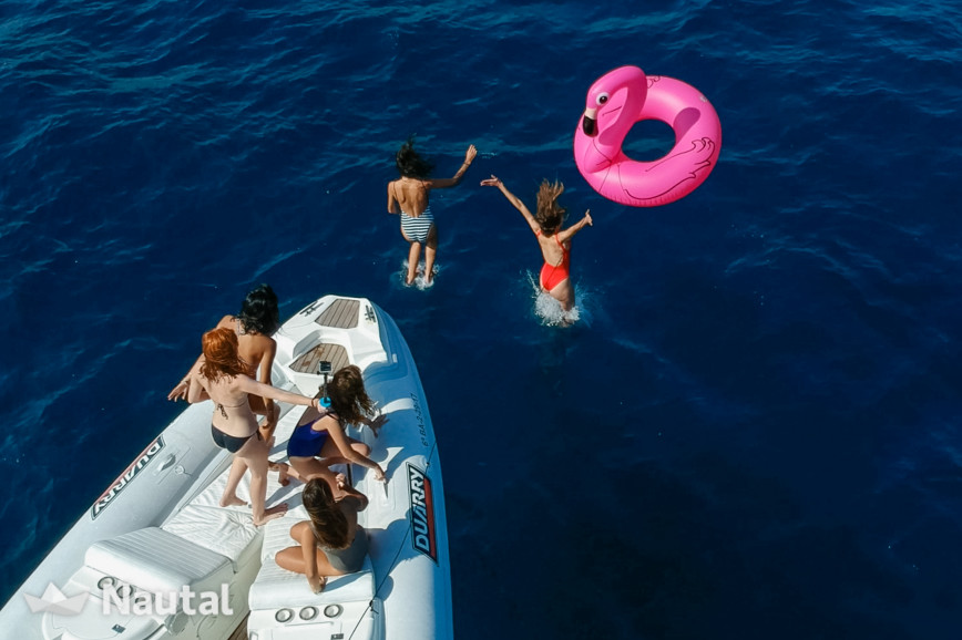 Chicas saltando de un barco en Barcelona con juguetes acuáticos inflables - Juguetes acuáticos indispensables para una celebración
