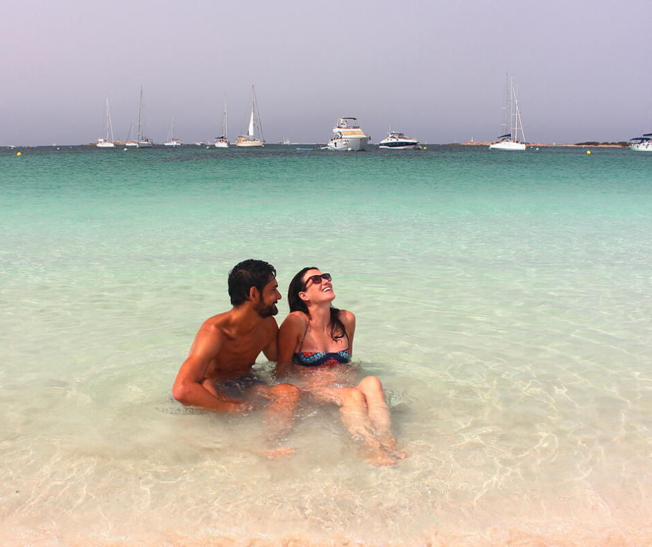 Una pareja disfrutando en la orilla del agua cristalina de Espalmador. 