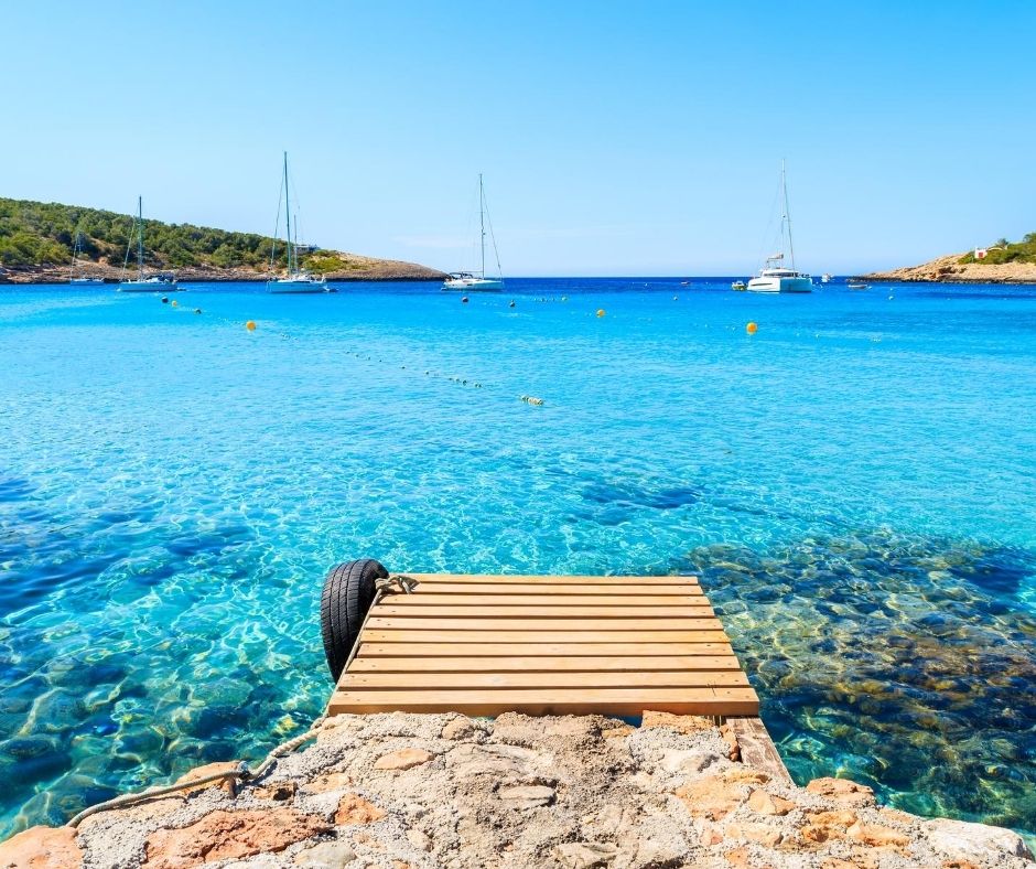 Ibiza pura diversión y agua turquesa, al fondo barco en Baleares