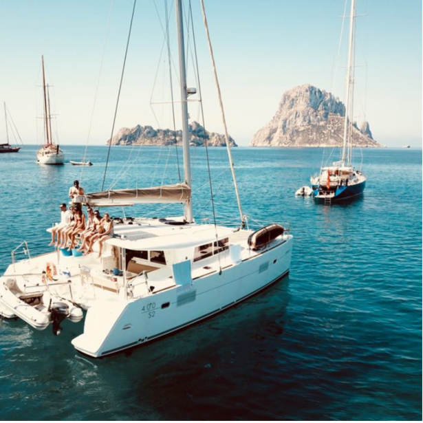 Tres barcos navegando en Cala d'Hort una de las mejores playas de Ibiza.