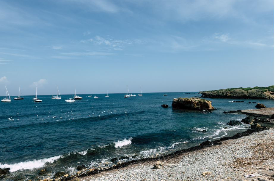 Playa de la Isla de Tabarca: playa sin bañistas a la vista, tan solo barcos navegando. 