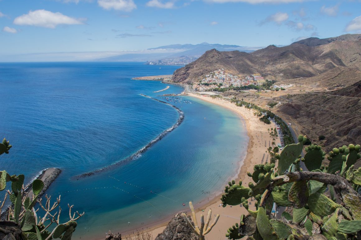 Extensa playa de aguas azules y arenas doradas en la costa de Tenerife.