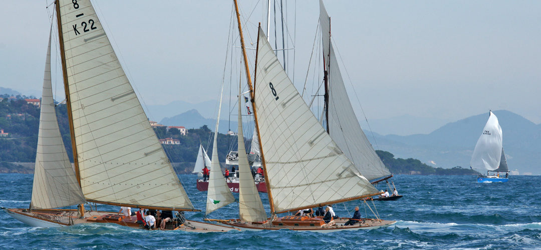 Trois voiliers Traditions s'affrontant dans une course de voile face à St Tropez, observés depuis un autre bateau.