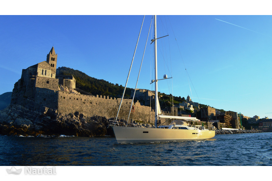 Barca a vela di fronte al castello del porto di alghero
