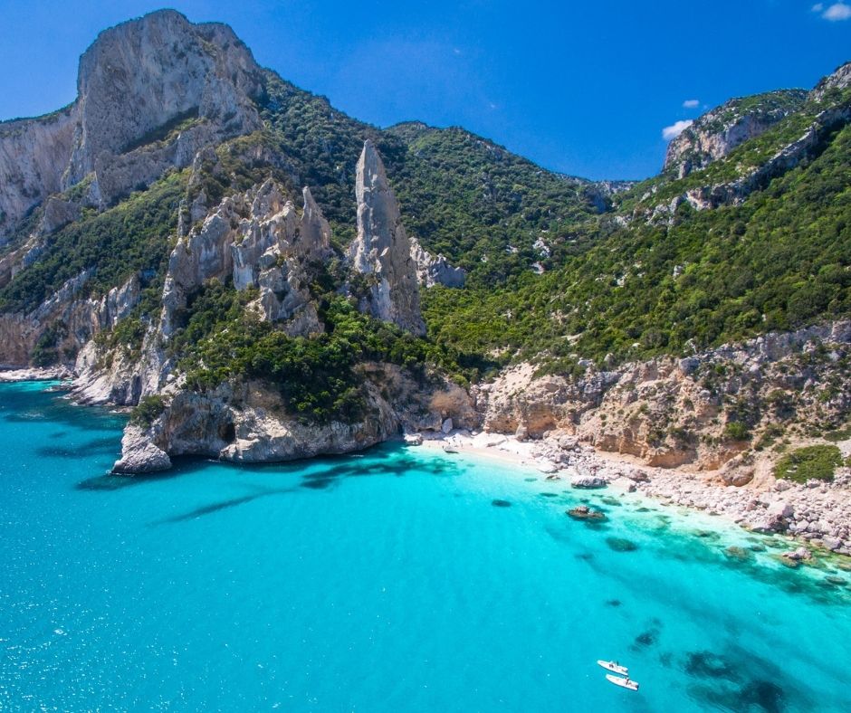 Costa della Sardegna, con spiagge bianche, acque cristalline e montagne verdi sullo sfondo