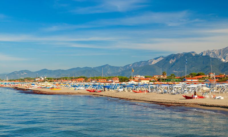 Spiaggia dei forte dei Marmi con ombrelloni e montagne di sfondo