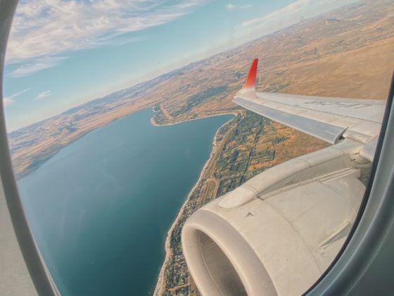 raam van een vliegtuig met uitzicht op de zee