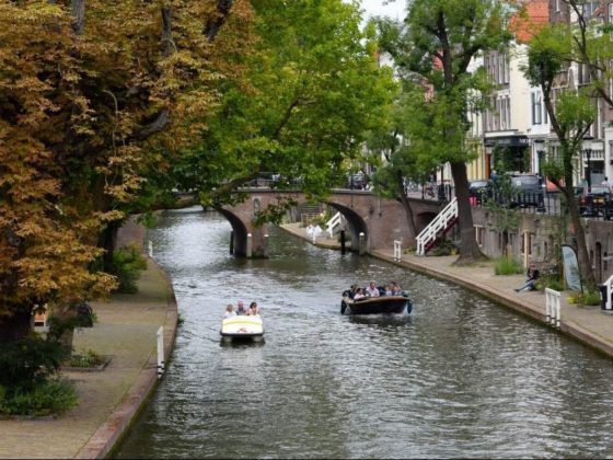 Twee boten varen op de Utrechtse grachten met de dubbele kades en historische panden