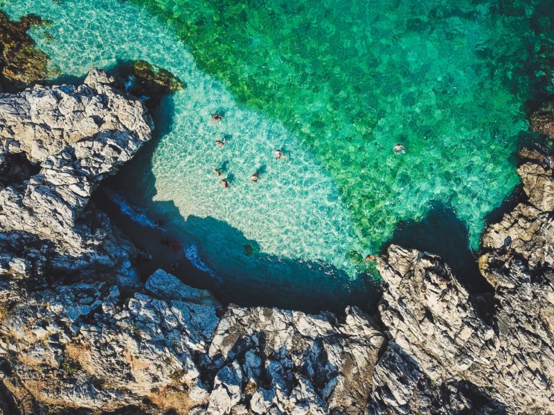 People swimming in the crystal clear waters of Sicily, the largest of the Mediterranean Islands