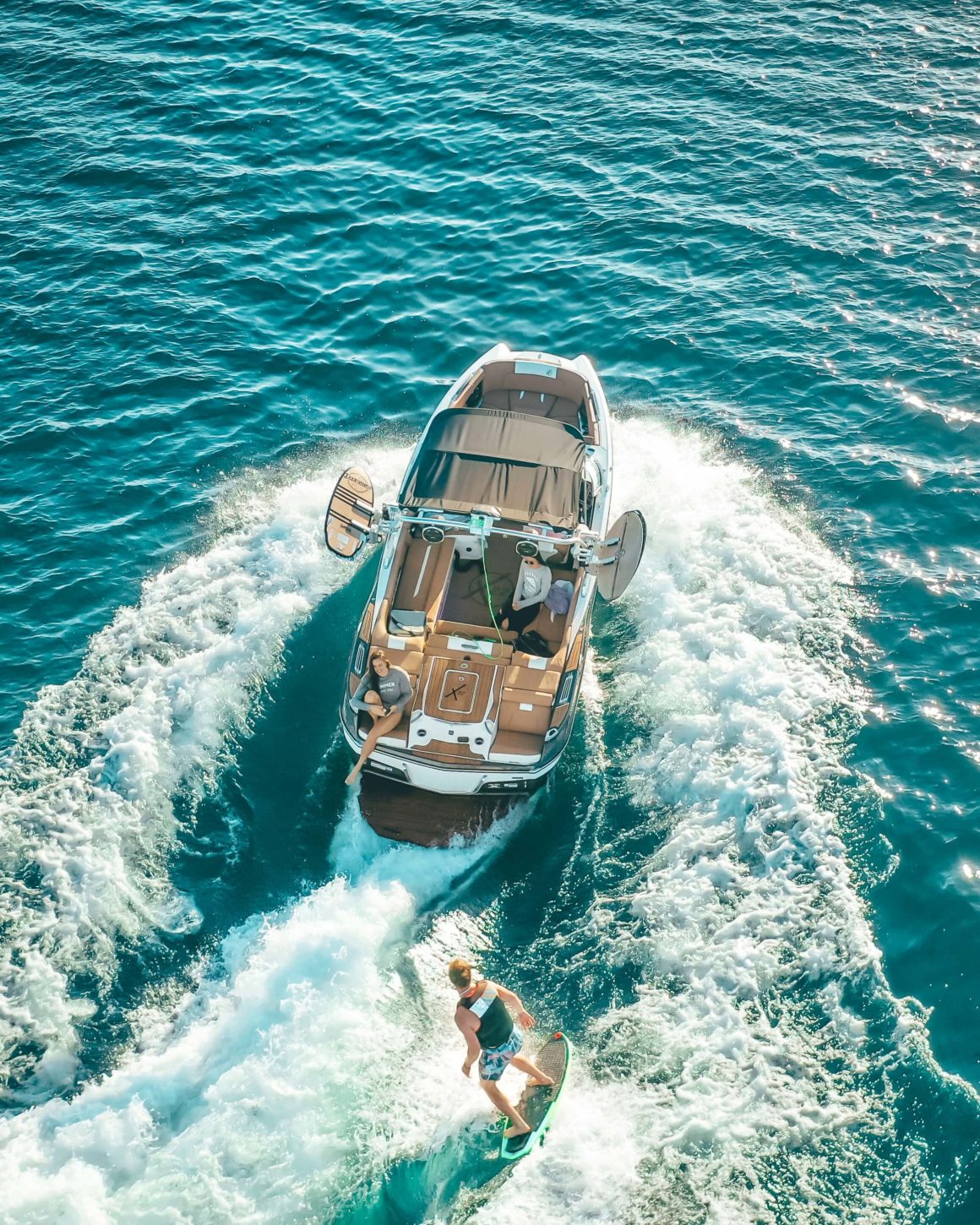 Aerial view of a wakeboard boat and a wakeboarder
