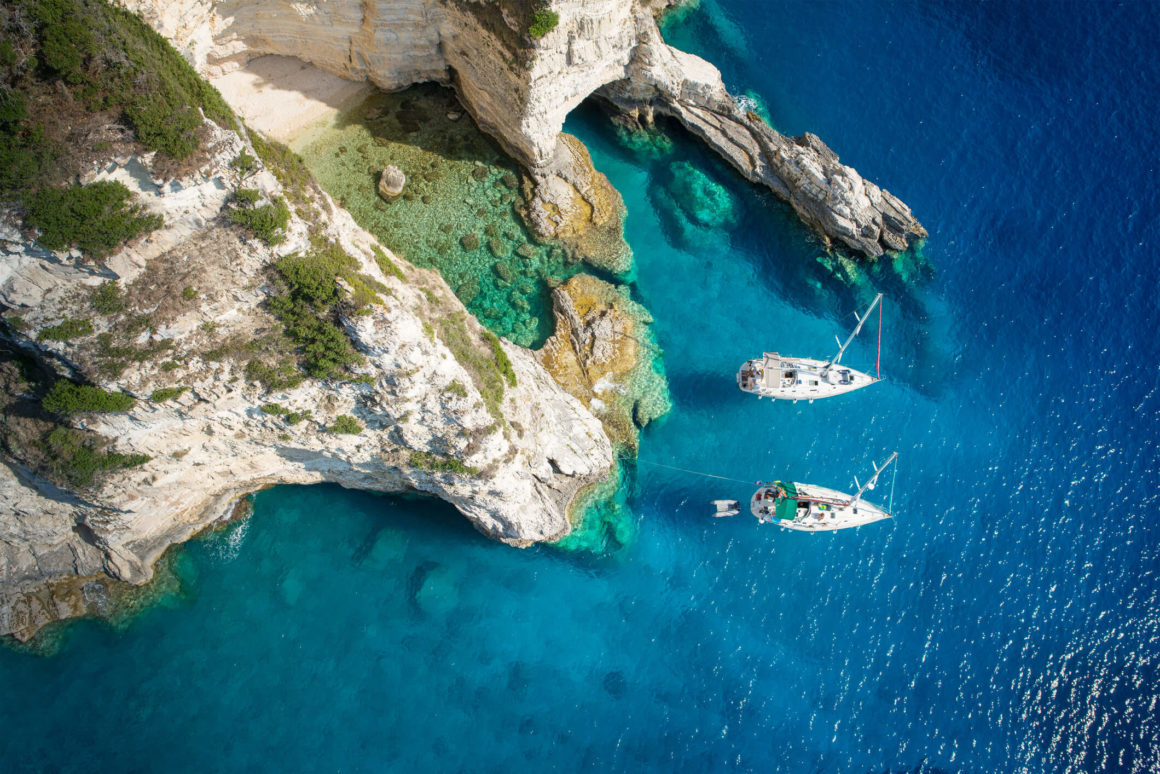 Two boats anchored at a cove while sailing in Greece