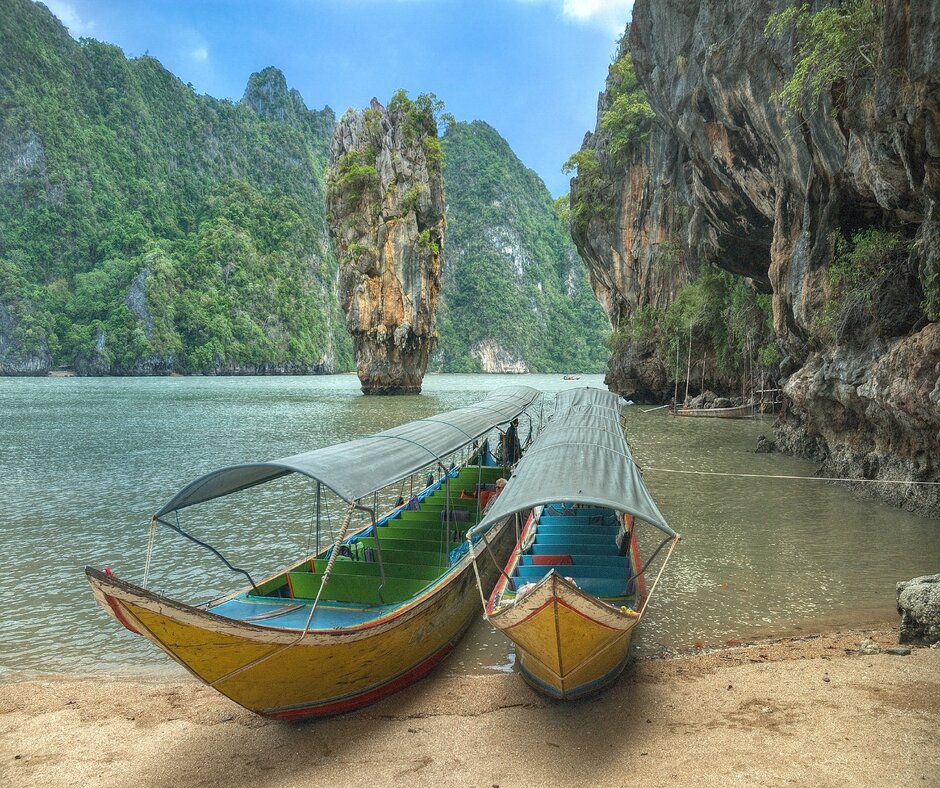 Tow traditional long tailed boats ashore in Phuket, Thailand. 