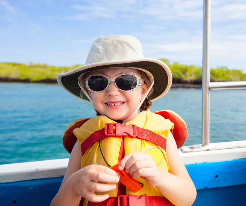 Young girl wearing a life jacket, floral sunglasses and a hat on a boat, sailing with your child