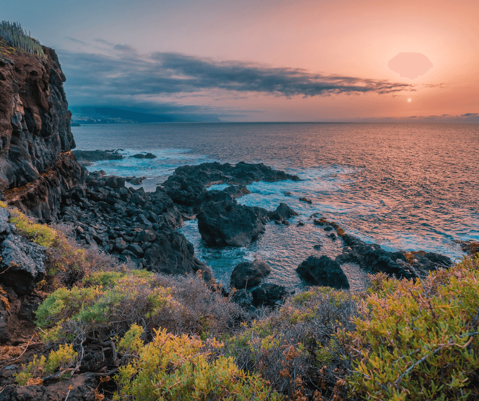 Pink sunset seen over the sea, from a high cliff. 